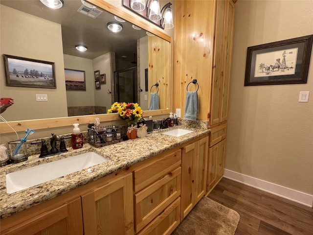 bathroom with vanity, wood-type flooring, and a shower with shower door