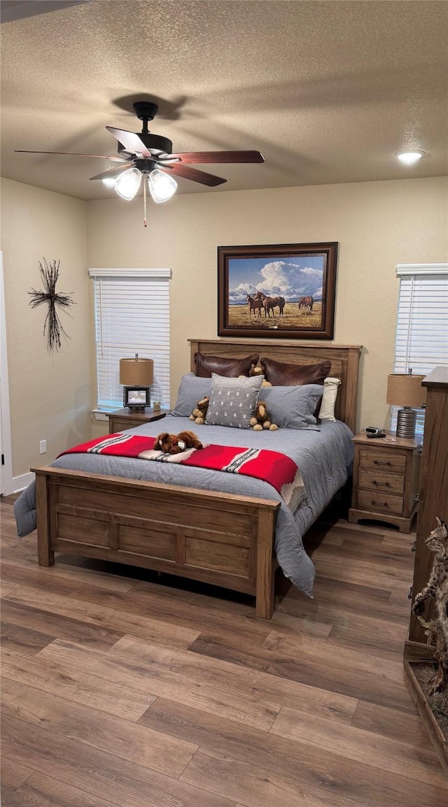 bedroom featuring hardwood / wood-style flooring, ceiling fan, and a textured ceiling