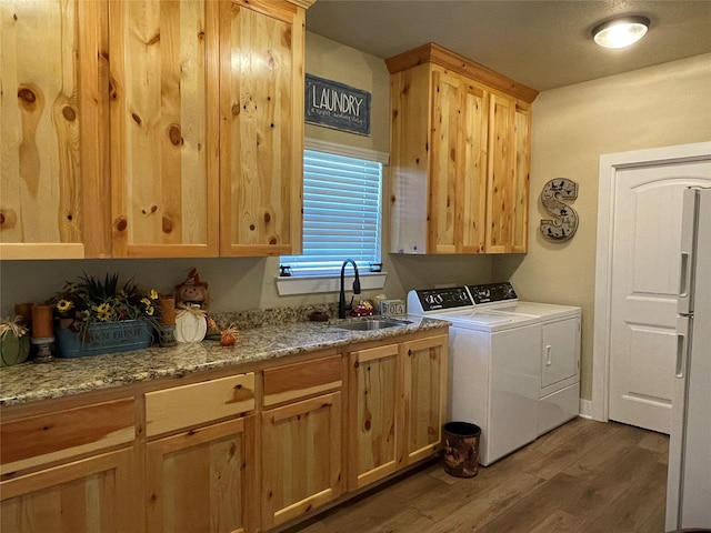 clothes washing area with dark hardwood / wood-style floors, sink, cabinets, and washer and clothes dryer