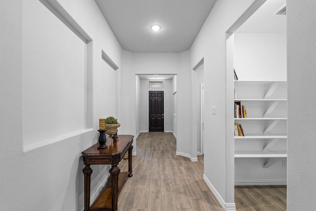 hallway with hardwood / wood-style flooring