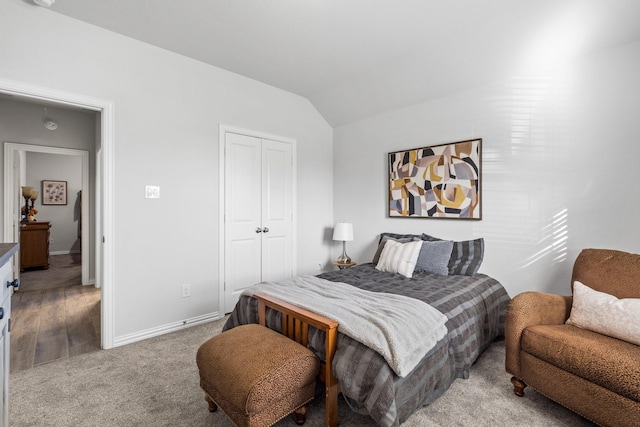 carpeted bedroom featuring vaulted ceiling and a closet