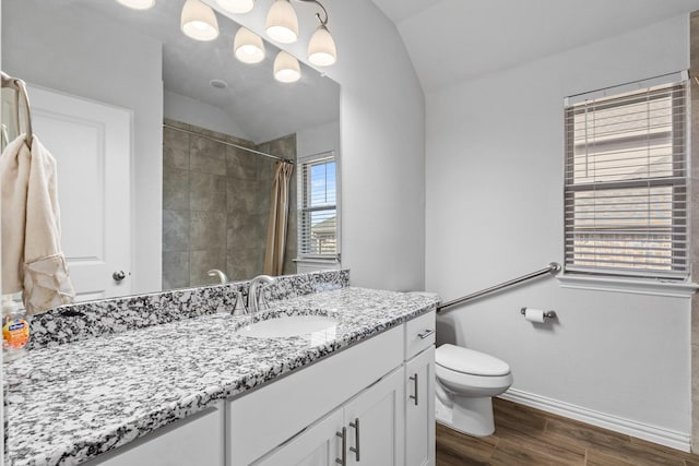 bathroom with hardwood / wood-style flooring, vanity, curtained shower, vaulted ceiling, and toilet