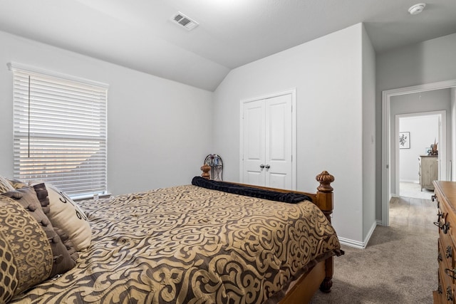 bedroom with light carpet, vaulted ceiling, and a closet