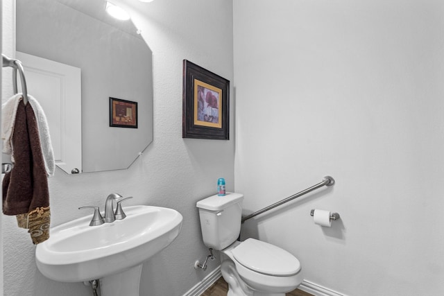 bathroom with sink, hardwood / wood-style floors, and toilet