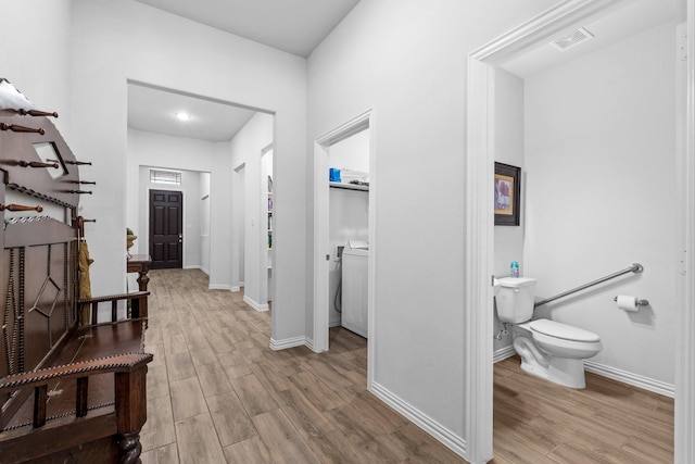 corridor featuring washer / clothes dryer and light hardwood / wood-style floors