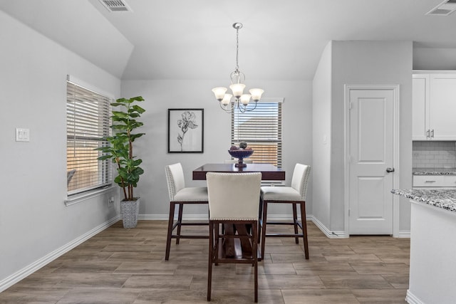 dining room featuring vaulted ceiling and a notable chandelier