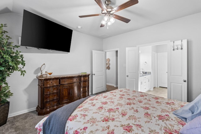 bedroom featuring ensuite bath, light colored carpet, and ceiling fan