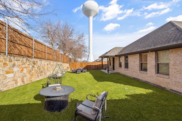 view of yard with an outdoor living space with a fire pit