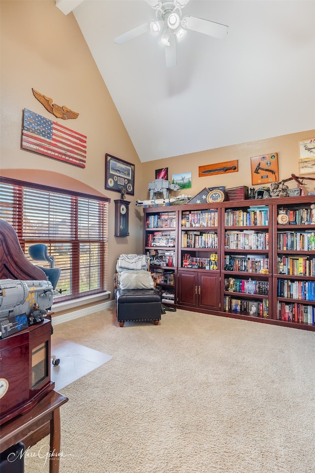 sitting room with ceiling fan, carpet floors, and high vaulted ceiling