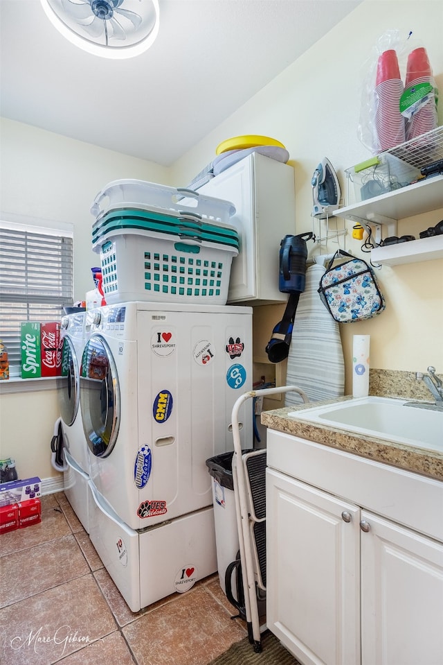 washroom featuring light tile patterned floors, sink, washer and clothes dryer, and cabinets