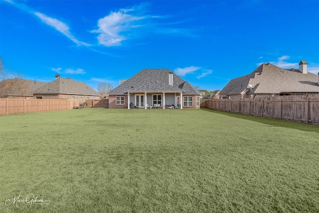 rear view of house featuring a lawn