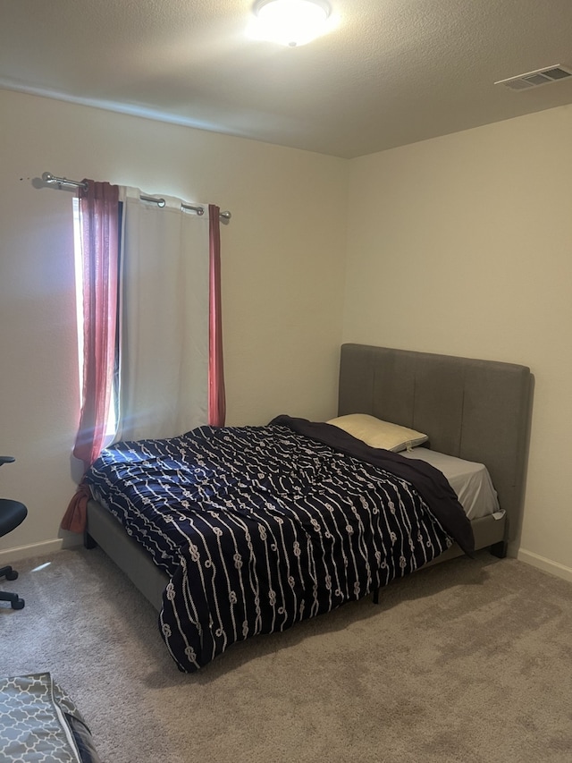 bedroom with carpet floors and a textured ceiling