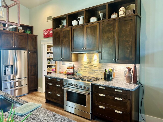 kitchen featuring light stone countertops, stainless steel refrigerator with ice dispenser, lofted ceiling, and light hardwood / wood-style floors