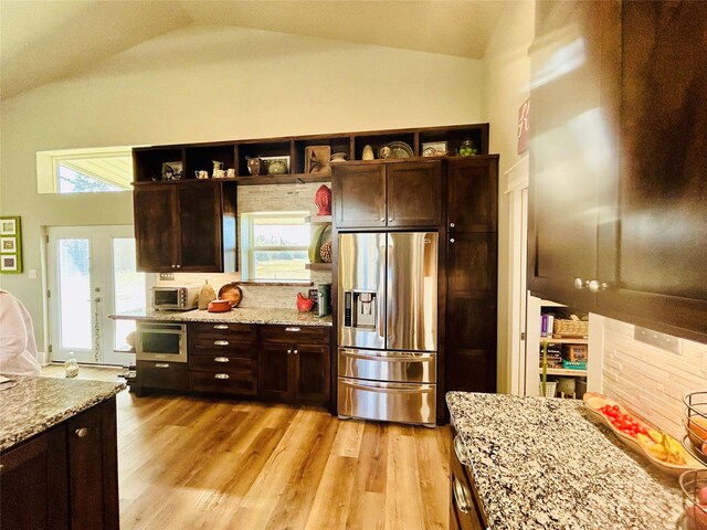 washroom with stacked washer and clothes dryer and light hardwood / wood-style floors