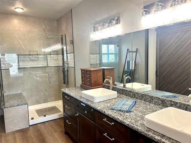 bathroom featuring vanity, hardwood / wood-style flooring, and a shower with door