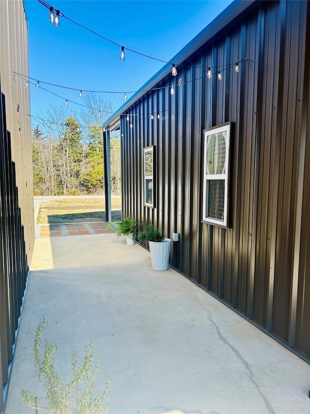 view of home's exterior with board and batten siding and a patio