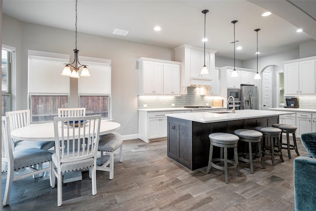 kitchen with white cabinetry, an island with sink, and appliances with stainless steel finishes