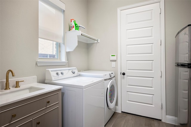 washroom with separate washer and dryer, sink, and dark hardwood / wood-style flooring