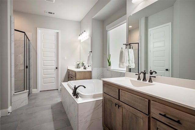 bathroom with vanity and shower with separate bathtub