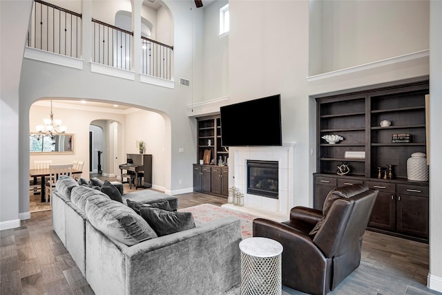 living room featuring a fireplace, wood-type flooring, and built in features