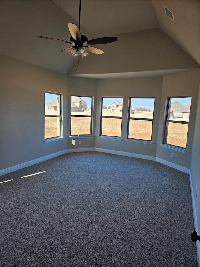 carpeted empty room featuring vaulted ceiling, ceiling fan, and plenty of natural light