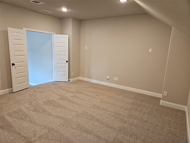 carpeted spare room with lofted ceiling