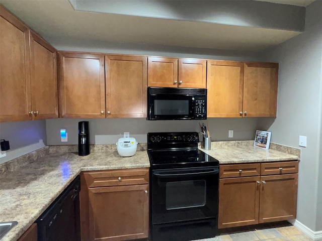 kitchen with light stone countertops and black appliances