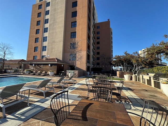 view of swimming pool with a patio, an outdoor kitchen, and a grill