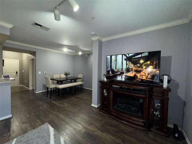 living room featuring dark wood-type flooring, crown molding, and rail lighting