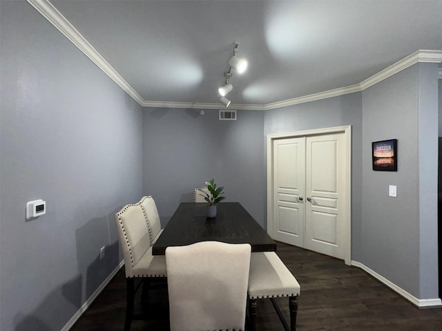 dining area featuring ornamental molding, dark hardwood / wood-style floors, and track lighting