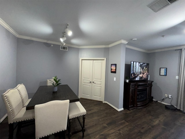 dining area featuring ornamental molding and dark hardwood / wood-style floors