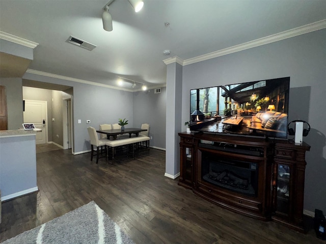 living room with dark wood-type flooring, crown molding, and rail lighting