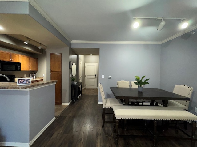 dining room featuring track lighting, ornamental molding, and dark hardwood / wood-style floors