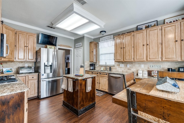 kitchen with a toaster, visible vents, appliances with stainless steel finishes, a center island, and crown molding