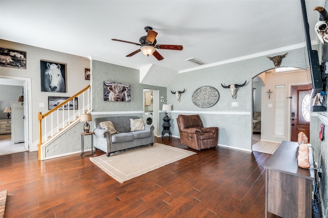 living area featuring arched walkways, visible vents, stairs, dark wood finished floors, and crown molding