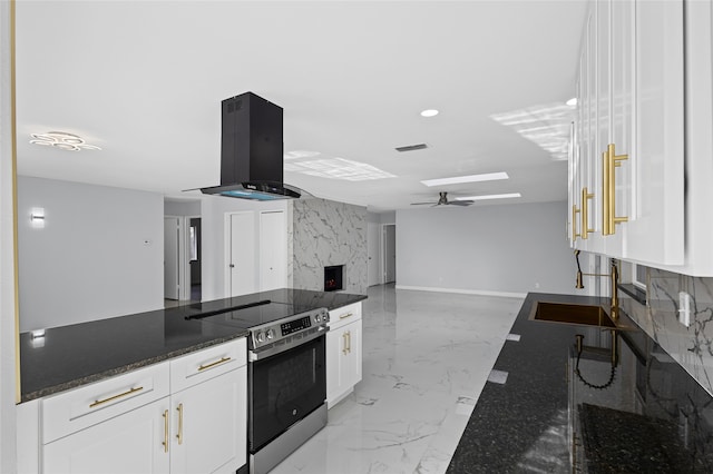 3521 Post Oak Rd, Garland, TX 75044 - kitchen featuring stainless steel range with electric stovetop, range hood, a sink, white cabinetry, and a ceiling fan