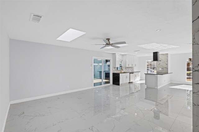 kitchen featuring tasteful backsplash, white cabinetry, sink, dark stone countertops, and stainless steel dishwasher