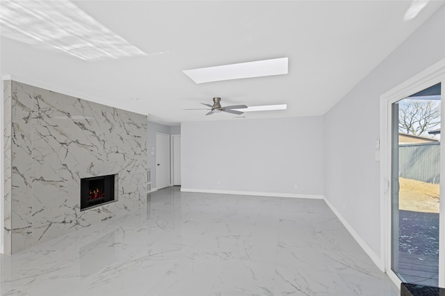 3521 Post Oak Rd, Garland, TX 75044 - unfurnished living room featuring a skylight, marble finish flooring, ceiling fan, a fireplace, and baseboards