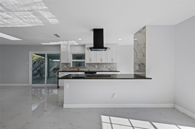 3521 Post Oak Rd, Garland, TX 75044 - kitchen with island range hood, light marble finish floors, white cabinetry, a skylight, and recessed lighting