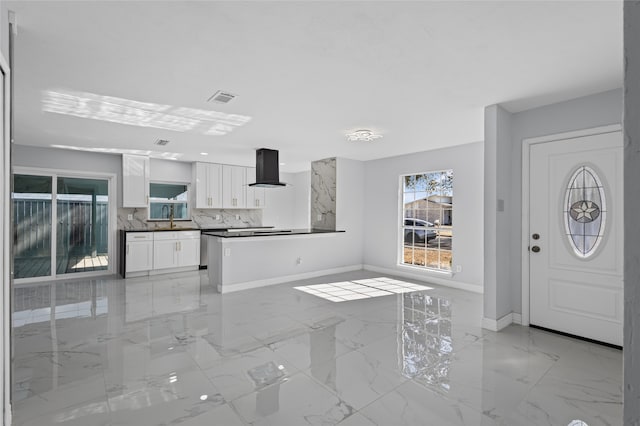 kitchen featuring white cabinetry, sink, tasteful backsplash, and range hood