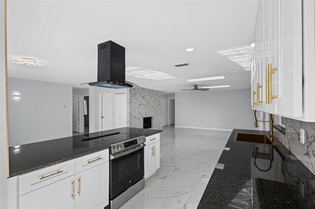 kitchen with tasteful backsplash, island exhaust hood, white cabinets, and kitchen peninsula