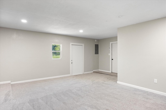 unfurnished room with light colored carpet and electric panel