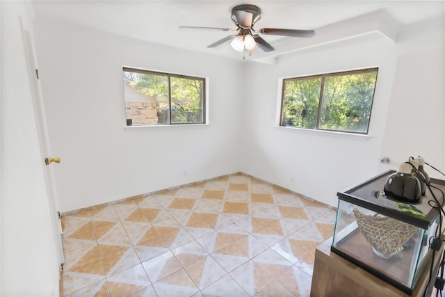 tiled spare room with ceiling fan and plenty of natural light