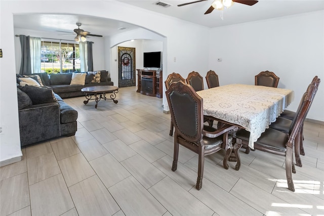 dining room with ceiling fan and a fireplace