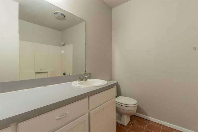 bathroom with tile patterned flooring, vanity, toilet, and walk in shower