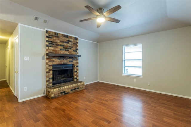 unfurnished living room with hardwood / wood-style floors, a brick fireplace, and ceiling fan