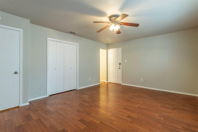 unfurnished bedroom featuring dark wood-type flooring and ceiling fan