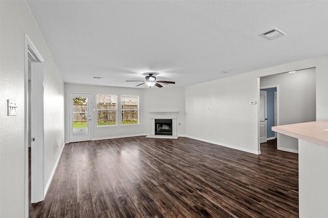 unfurnished living room featuring dark wood-type flooring and ceiling fan