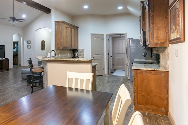 kitchen featuring dark hardwood / wood-style floors, lofted ceiling with beams, and a breakfast bar