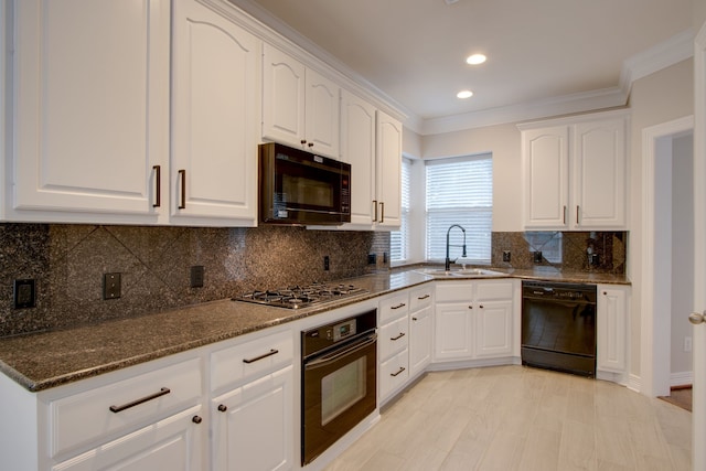 kitchen featuring white cabinetry, dark stone countertops, sink, and black appliances